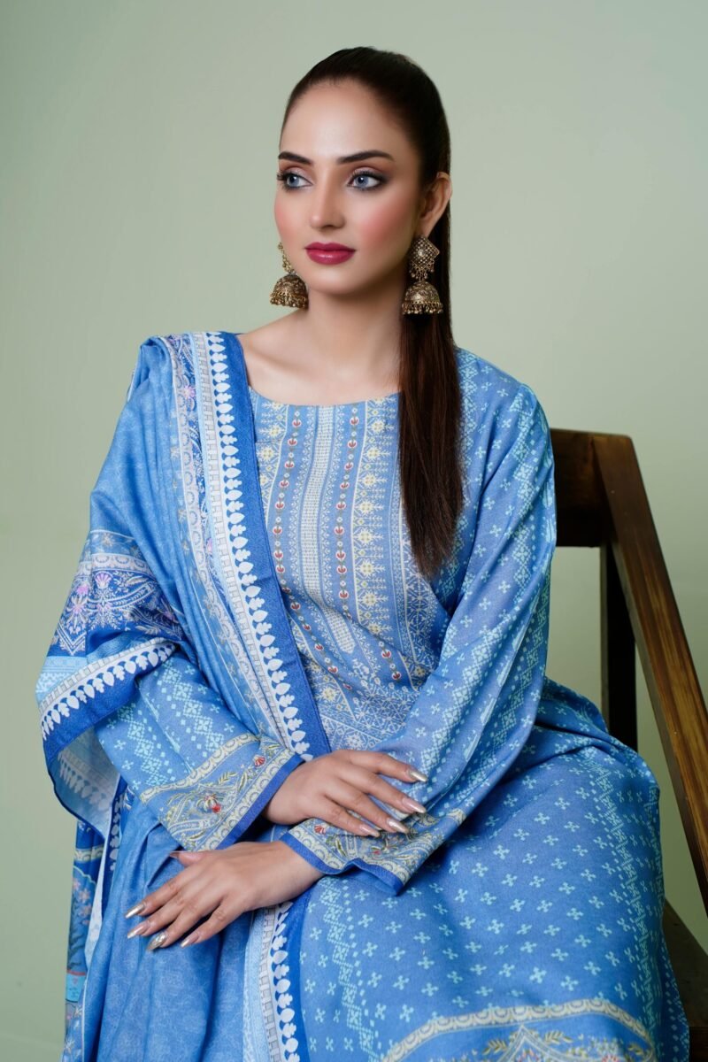 A model in blue traditional Indian attire poses elegantly indoors, highlighting fashion and cultural beauty.